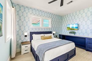a bedroom with a bed and a blue wall at Wayward Sun Luxury 4BR Gulf Retreat w Pool, Hot Tub & Elevator in Port Bolivar +79 photos