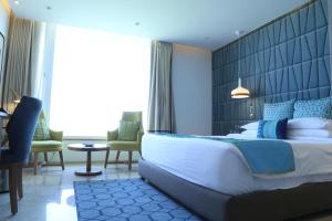 a hotel room with a large bed and chairs at The Park Visakhapatnam in Visakhapatnam