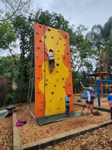 eine Gruppe von Kindern, die auf einer Kletterwand auf einem Spielplatz spielen in der Unterkunft Cabana Hostel Eco Park in São Pedro