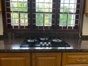 a stove top in a kitchen with windows at The White House in Thodupuzha +14 photos