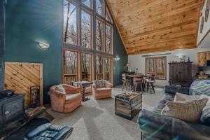 a living room filled with furniture and a wooden ceiling at Sqyrls Nest - Hot Tub, Pet Friendly, Screen Porch, Grill, Wifi, Fire Pit, Deck, View, Family Friendly, Game Room, Shuffle Board, Wood Stove in Berkeley Springs
