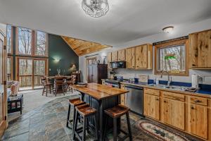 a kitchen with wooden cabinets and a table and chairs at Sqyrls Nest - Hot Tub, Pet Friendly, Screen Porch, Grill, Wifi, Fire Pit, Deck, View, Family Friendly, Game Room, Shuffle Board, Wood Stove in Berkeley Springs