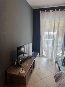 a living room with a tv and a large window at Apartments Paradiso Verde in Eretria