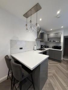 a kitchen with a white counter and a kitchen island at A home away from home in Manchester +18 photos