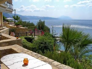 an orange vase sitting on a stone table near the water at Miradouro Sea Front Residences in Ilia