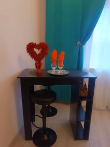 un tavolo nero con due bicchieri da vino e uno sgabello di Eduard Elegance Rin Studios a Bucarest