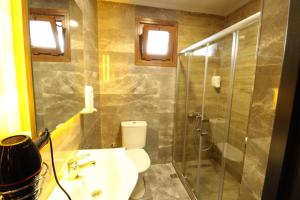 a bathroom with a toilet and a glass shower at Sahra Kent Otel Kadıköy in Istanbul +46 photos