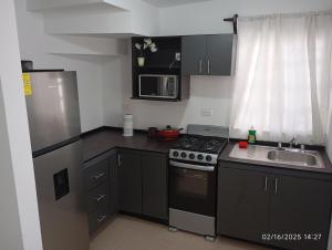 a small kitchen with a stove and a sink at Casa arcilla clima total Starlink zona Aeropuerto in Villa Juárez