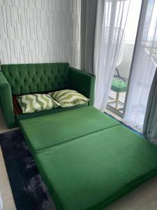 a green couch in a room with a window at AMIRAH'S PLACE 1BEDROOM UNIt in San Fernando +16 photos