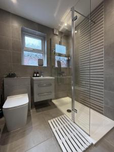 a bathroom with a shower and a toilet and a sink at A home away from home in Manchester