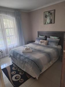a bedroom with a bed with two towels on it at Caribbean Estate Guest House B11 in Port Edward