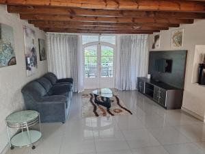 a living room with a blue couch and a tv at Caribbean Estate Guest House B11 in Port Edward