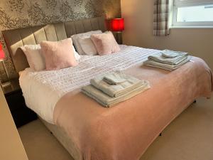 Un dormitorio con una cama con toallas. en Sleeps 4 6 pet friendly parking nr nec Warwick uni, en Coventry