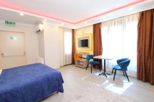 a bedroom with a blue bed and a table and chairs at Sahra Kent Otel Kadıköy in Istanbul
