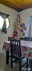 comedor con mesa y pared de flores en Ty Hapus, en El Bolsón