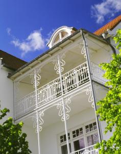 einen Balkon an der Seite eines weißen Hauses in der Unterkunft Appartementhaus Bellevue Binz in Binz