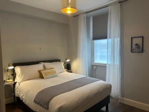 a bedroom with a large bed with a window at Comfortable one-bedroom apartment Free parking space in Edinburgh