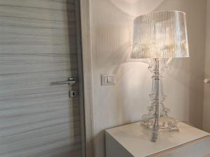 a white lamp sitting on top of a dresser at Il Nido nel Cuore di Modena in Modena
