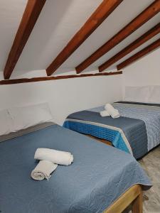 two beds with towels on top of them in a room at Villa Girasol in Villa de Leyva +73 photos