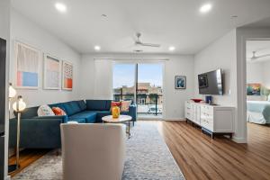 uma sala de estar com um sofá azul e um quarto em The Mercer em New Braunfels