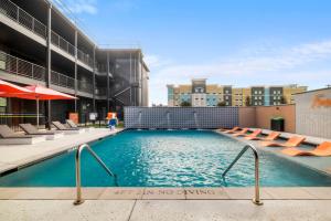 uma piscina com cadeiras num edifício em The Mercer em New Braunfels