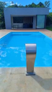 a blue swimming pool with a trash can next to it at Casa de campo Serra do Cipó in Serra do Cipo