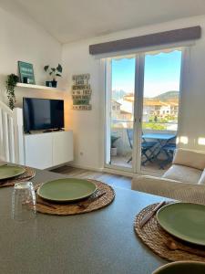 a living room with a table with green plates on it at Nid du port in Grimaud +13 photos