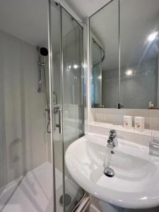 a white bathroom with a shower and a sink at Nid du port in Grimaud