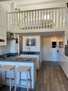 a kitchen with a loft with a sink and stools at Nid du port in Grimaud