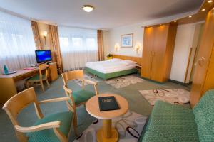 a hotel room with a bed and a table and chairs at Hotel Brack in Munich