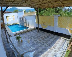 a patio with a table and a swimming pool at MICASO Guest House in Limbe
