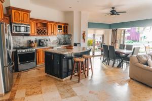 a kitchen with wooden cabinets and a table with chairs at Casa Amigos , entire 3 bedroom ground floor condo at Playa Grande Condominium Resort in El Coco