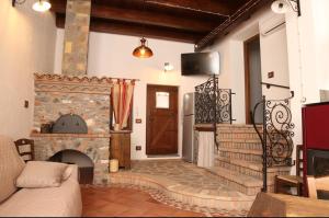 a living room with a stone fireplace and a door at Villa Manca in San Severino Lucano