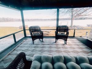 two chairs and a couch in a screened in porch at Lakefront Girls getaway Romantic Retreat low fees in Howe