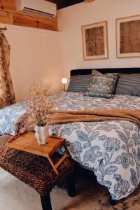 a bedroom with a bed and a table with a vase on it at Lakefront Girls getaway Romantic Retreat low fees in Howe