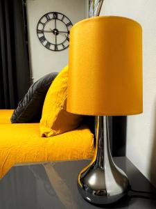 a lamp on a table next to a bed with a clock at London Studio in London