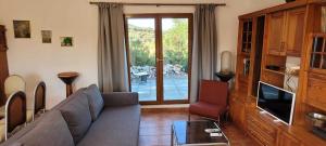 a living room with a couch and a sliding glass door at Sítio da Cornucópia Casa Principal in Moncarapacho
