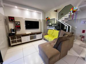 a living room with a couch and a tv at Casa Gravata in Gravatá