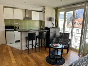a kitchen with a counter and chairs in a room at Appartements Residilaverde Gare in Grenoble