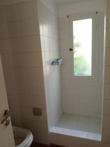 baño con ducha, aseo y ventana en Departamento en complejo ''Los abedules'', en Balcarce