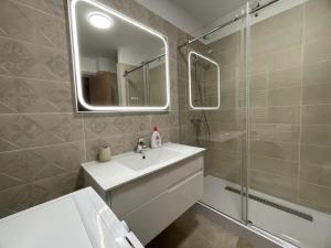 a bathroom with a sink and a shower and a mirror at AME Summer - Onix Blue Mamaia Nord in Mamaia Nord +16 photos