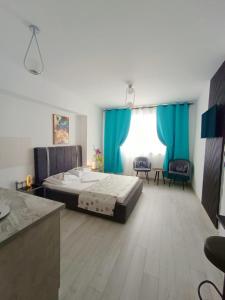 una camera con un grande letto e tende blu di Eduard Elegance Rin Studios a Bucarest Altre 93 foto