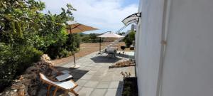 a patio with two chairs and an umbrella at Sítio da Cornucópia Casa Principal in Moncarapacho