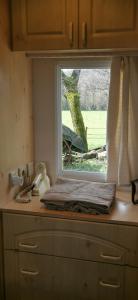 a window on top of a dresser in a kitchen at La Petite Maison dans La Mégie Tiny House in Troche