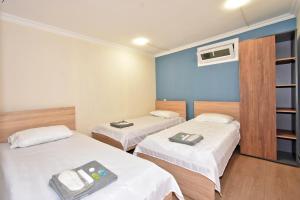 una camera d'albergo con due letti e una tv di P&A guest house a Yerevan