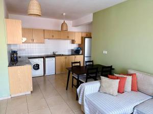 a living room with a couch and a table in a kitchen at Limassol Star Complex Seaview Apartment in Limassol