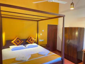 a bedroom with a bed with a wooden canopy at Luxe Hiriketiya in Hiriketiya