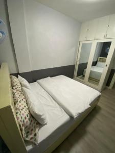 a bed in a room with a mirror at Quiin Home cozy modern house in Pampang