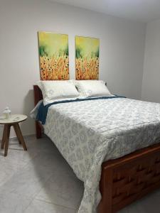 a bedroom with a bed with two paintings on the wall at Beach Life Mirante dos Golfinhos in Nísia Floresta +29 photos