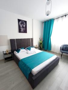 a bedroom with a large bed with a blue blanket at Eduard Elegance Rin Studios in Bucharest +79 photos